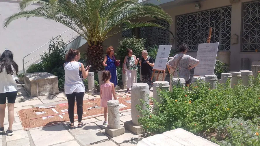 Φωτογραφικό τεκμήριο από το «Άχρονο Πλέγμα»: στιγμιότυπα από την προετοιμασία της ομάδας και από την παρουσίαση στο αίθριο του Επιγραφικού Μουσείου, όπου τα έργα στρώθηκαν σε κάναβο ανάμεσα σε αρχαίους κίονες, σαν ευρήματα ανασκαφής.
